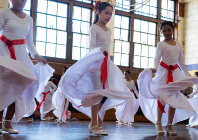 Girls in white dresses, dancing.