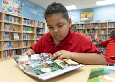 A student in a library looking at a graphic novel.