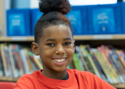 Close-up of a student in a library, smiling.