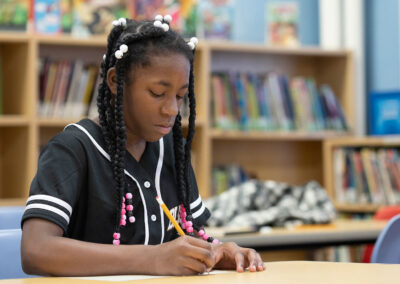 A girl in a library writing.