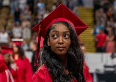 A student in a cap and gown in an auditorium.
