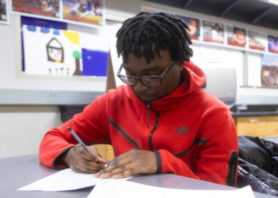 A student in a classroom writing.