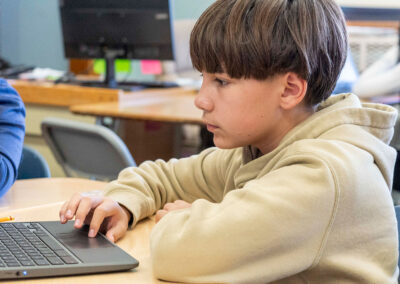A child in a classroom using a computer.