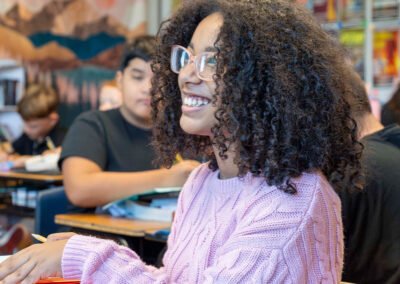 A smiling girl in a classroom.