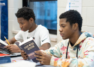 Two students reading the book "Every Other Weekend."