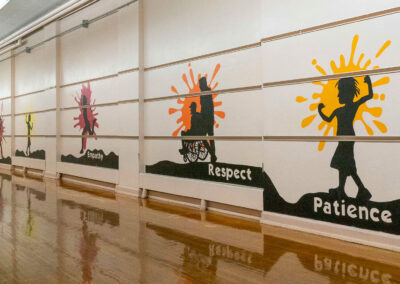 A hallway with different murals for patience, respect, and empathy.
