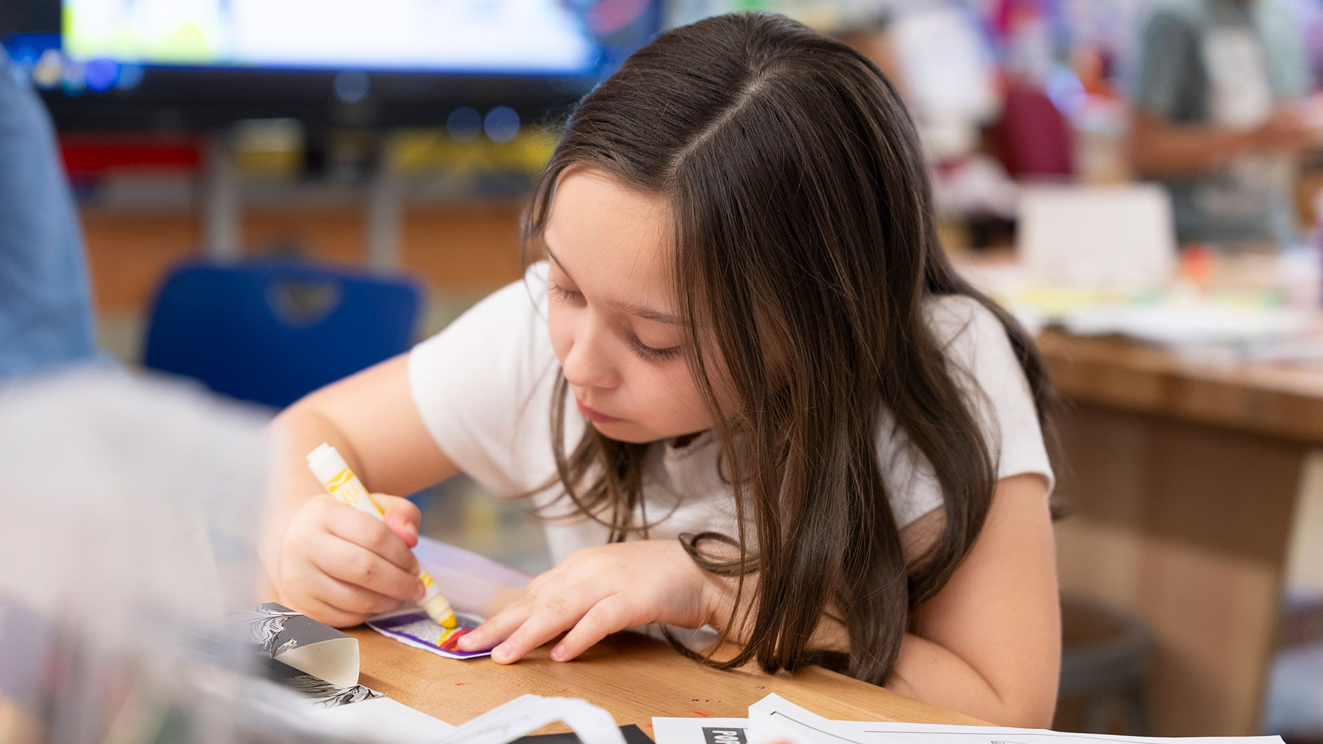 A young girl concentrates while coloring.