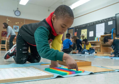 A student on the floor learning to count to 100.