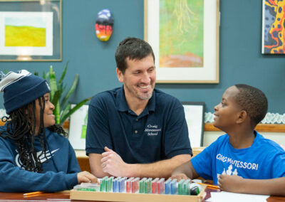 A teacher smiles at his students as they smile back.