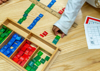 Overhead view of a student's hand placing a 1000 tile on a table.