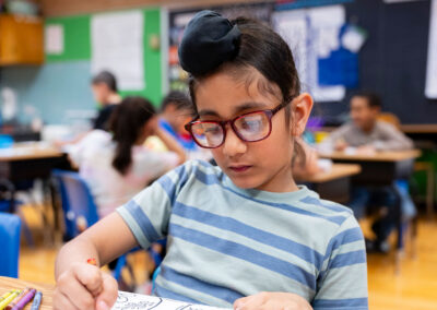 A child in a classroom at a table coloring.