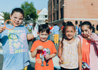 Four young students stand next one another at the end of year carnival.