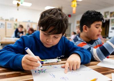 Students in a classroom coloring.