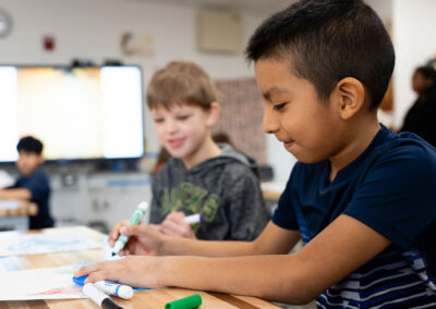 Students in a classroom coloring.