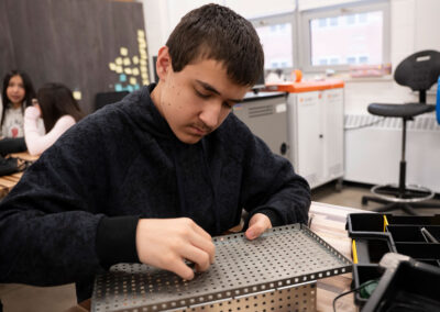 A student at a table building with an engineering kit.