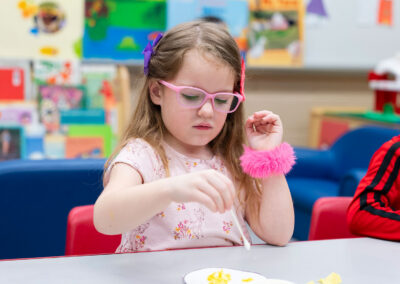 A young child at a table working on an art project.