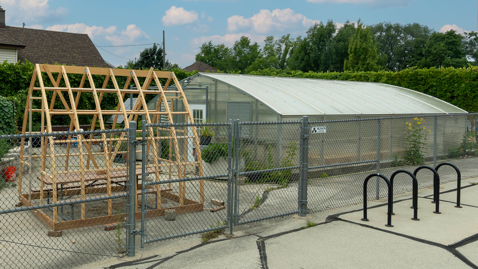 A greenhouse behind a fence.