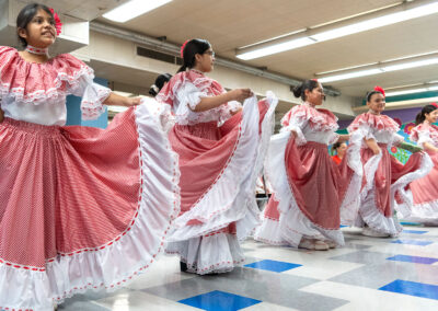 Young girls in colorful dresses dancing.