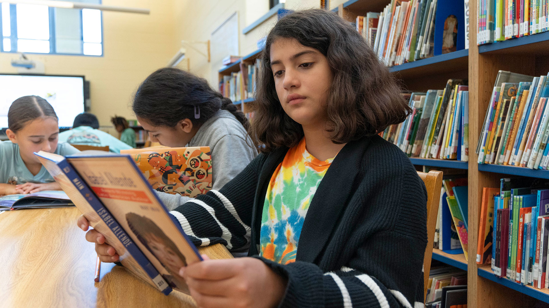 A girl in a library reading.