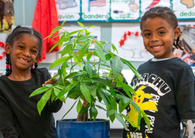 Ob tug me nyuam yaus nrog ib tsob nroj.