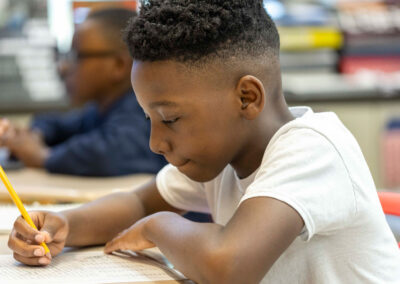 A serious boy at a desk doing a word search.