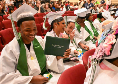 Graduates laugh after receiving their diplomas.