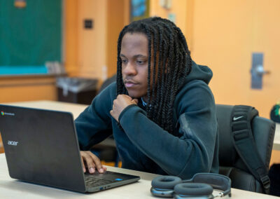 A student at a desk using a computer.