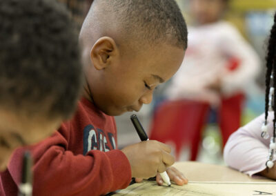 A young student carefully writing.