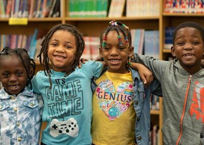 أطفال صغار في مكتبة وهم يضعون أذرعهم حول بعضهم البعض.