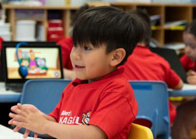 Un niño pequeño sonríe en clase.