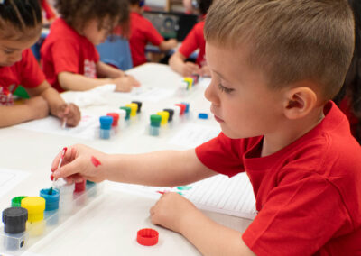 Niños pequeños en un aula practican el trazado de letras.