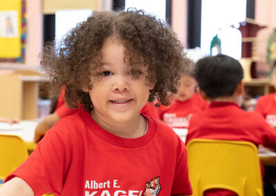 Un niño pequeño sonríe en clase.