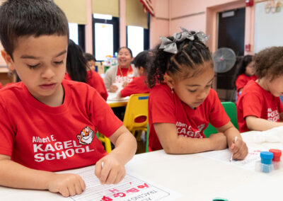 Niños pequeños en un aula practican el trazado de letras.