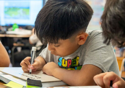 Los niños pequeños escriben en pequeñas pizarras blancas.