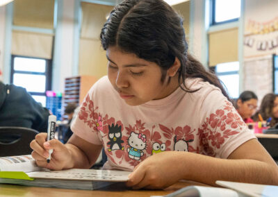 Un alumno escribe en una pequeña pizarra blanca.