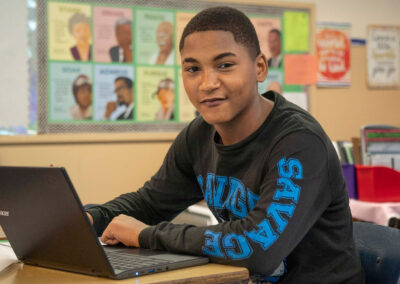 A boy at a desk with a computer.