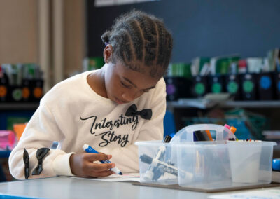 A young student at a table coloring.