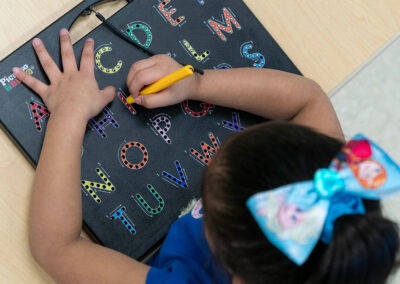 Overhead view of a student tracing letters.