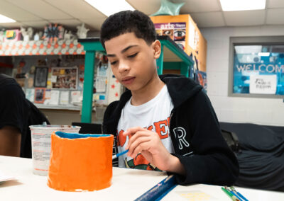 A student painting a vase.