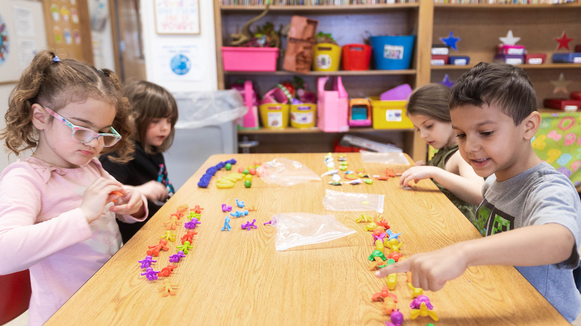Young children at a table practice counting.
