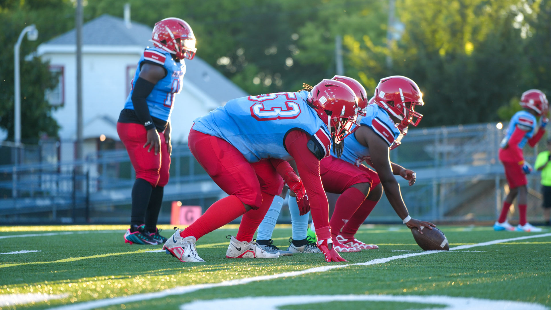 Football players ready to snap the ball.