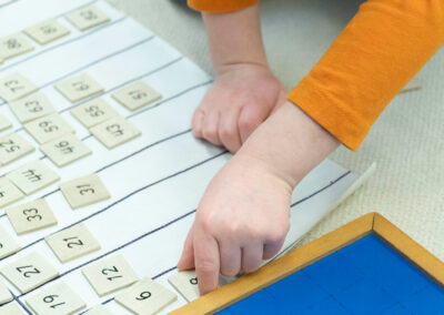 Close-up of a hand sorting numbers into columns of 10s, 20s, etc.