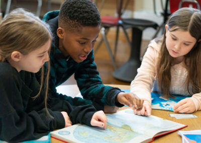 Three students looking in an atlas.