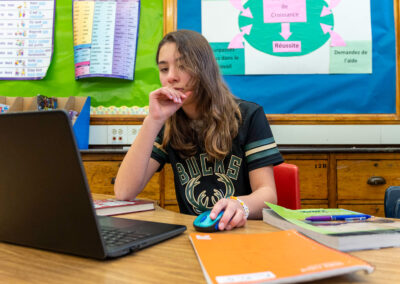 A child at a table using a computer.