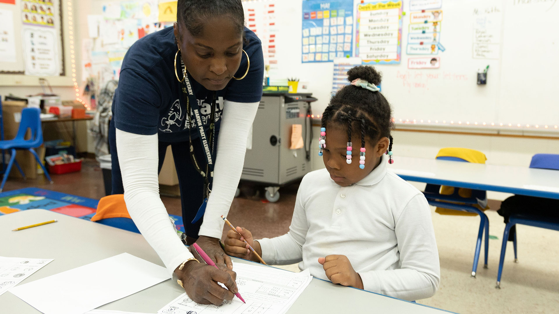 A teacher helps a young student.