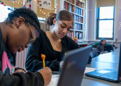 Students in a classroom work on homework.