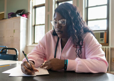 A girl at a desk writing.