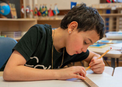 A student using a ruler to draw a line.