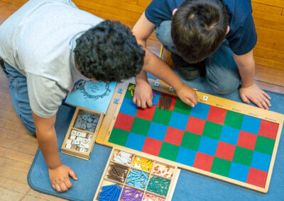 Overhead view of two young students using beads to count.