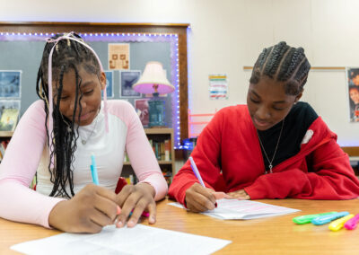 Two students in a classroom working on an assignment.
